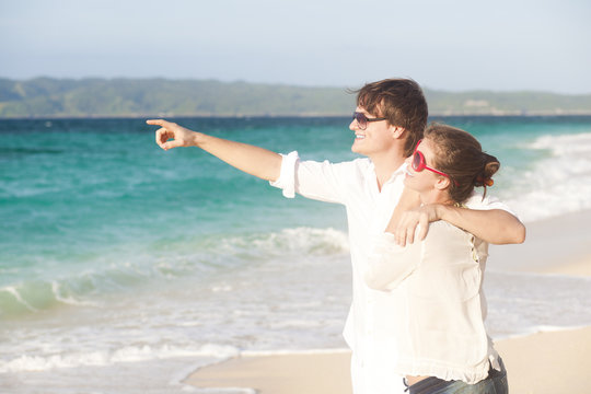 young happy couple having fun on tropical beach. honeymoon