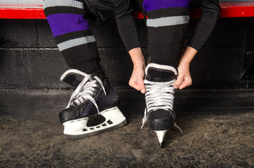 Fototapeta premium Child Tying Hockey Skates in Dressing Room