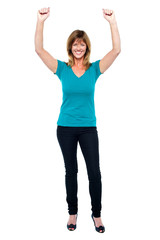 Excited woman in celebration mood with raised arms