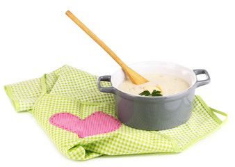 Mashed potatoes in saucepan on green pinafore isolated on white