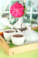 Cups of tea with flower and teapot