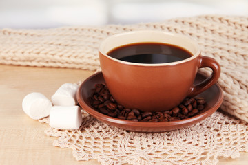 cup of coffee with scarf on table in room
