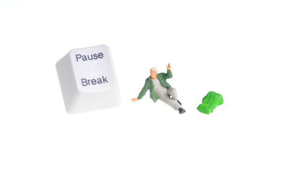 Tiny figure of hiker siting next to pause - break key