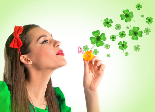 Beautiful woman making four leaf clover bubbles