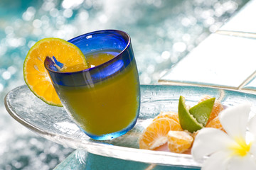 orange cocktail in blue glass by Jacuzzi pool