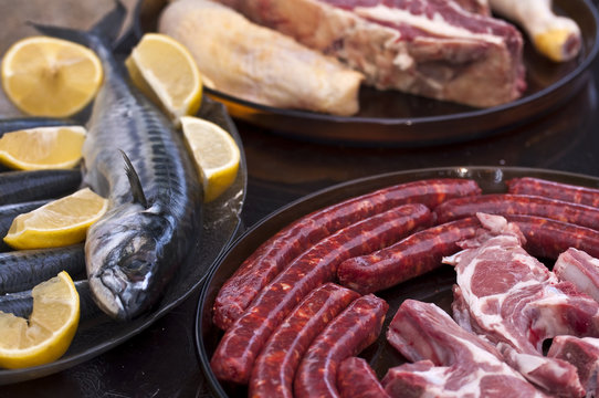 Plateau de viande, saucisses, merguez et poisson cru pr&ecirc;ts &agrave; cuire pour un barbecue