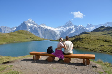 Travelers on a bench enjoying Alpine panorama