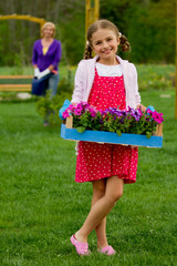 Gardening, planting -  girl helping mother in the garden