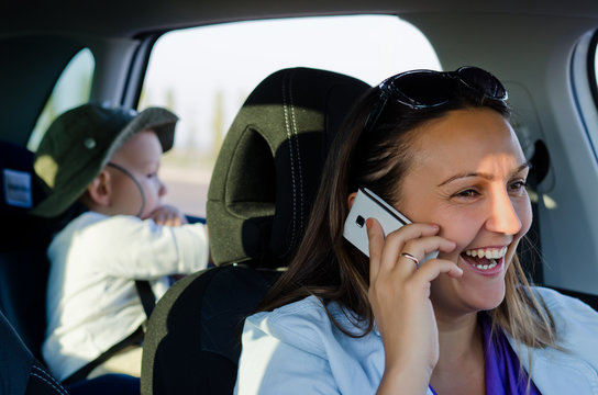 Woman driver laughing on her mobile phone
