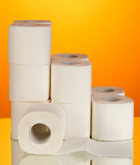 Rolls of toilet paper on orange background
