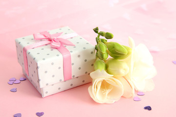 Beautiful romantic gift box and flower on pink background
