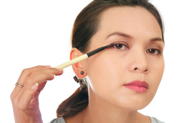 Isolated middle age asian woman with make up brush.