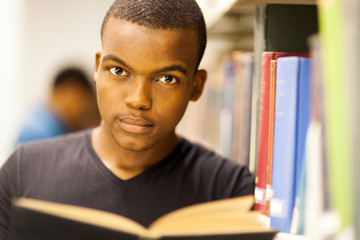 male african american college student reading in library