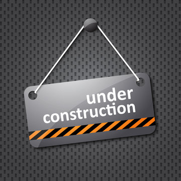 under construction sign hung on a textured background