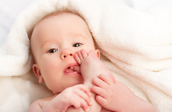 small baby sucking her finger on leg