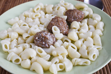 macaroni and meatballs with sauce in a plate