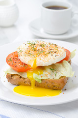 toast with tomato, lettuce and poached egg for breakfast