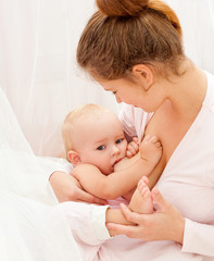 Obraz na płótnie Canvas Mother breast feeding her infant