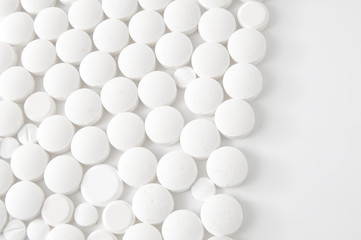 White pills on white background - medical concept