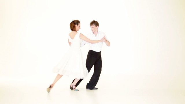 passionate, young couple showing dance moves on white background