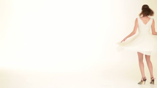 woman twirling around a white dress, on white background