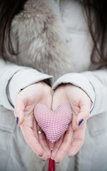 Heart made of fabric in hands
