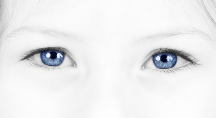 Close up on a beautiful blue eyes of a young girl
