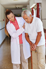 Krankenschwester hilft Senior mit Gehstock