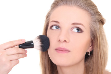 young attractive woman with make-up brush over white