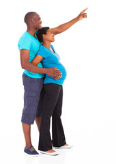 Fototapeta premium expecting african american couple pointing at empty copy space