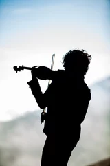 Foto op Plexiglas violinist silhouetted on volcano © paulcowell