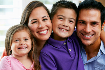 Family Sitting On Sofa At Home Together