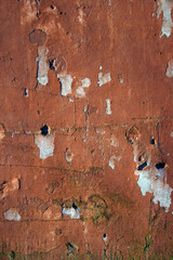 Grungy wall with peeling red paint