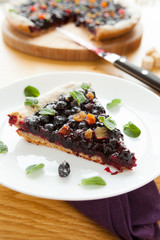 piece of berry pie on a white plate, leaf oregano