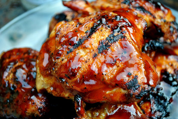 Crispy barbeque chicken thighs, top view, macro shot. © Bill