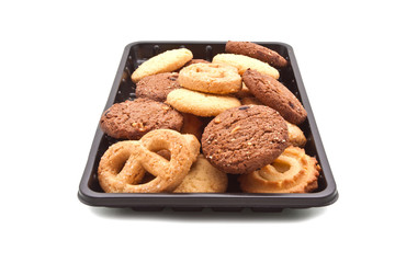 Heap of cookie on black plastic tray, isolated on white
