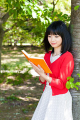 Fototapeta premium atractive asian woman reading a book in the park
