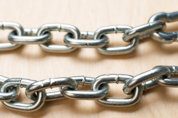 Fototapeta premium Two Chain Links on Wooden Table