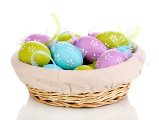 Colorful easter eggs in basket isolated on white