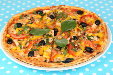Tasty pizza on blue tablecloth close-up