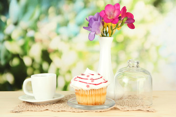 Cupcake on saucer with glass cover, on bright background