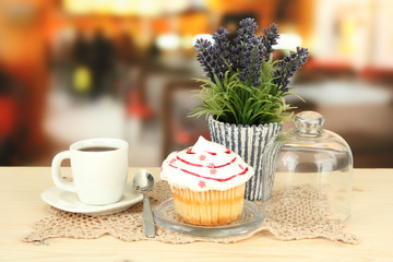 Cupcake on saucer with glass cover, on bright background