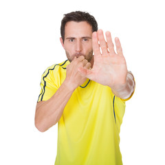 Soccer judge whistling and showing stop sign