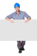 Portrait of happy worker presenting empty banner