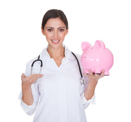 Young Female Doctor Holding Piggy Bank