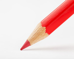 red pencil draws or writing on white paper sheet