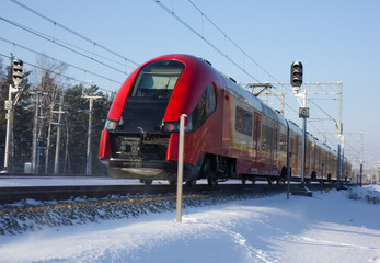 High-speed modern commuter train riding among snows