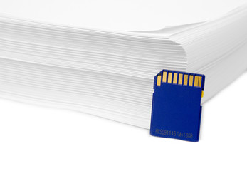 Sd memory card with a stack of printer paper. Hardcopy backup or