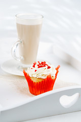 red festive muffin and coffe Latte in a glass, on white wooden t