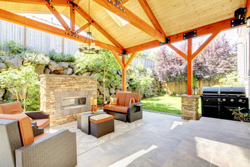 Exterior covered patio with fireplace and furniture. - 49258383